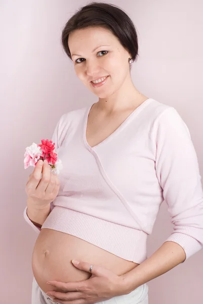 Gravid flicka håller en blommor — Stockfoto