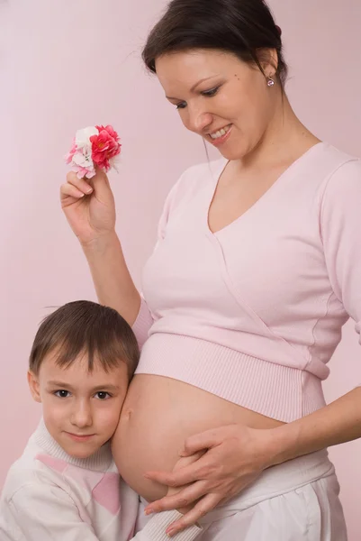 Беременная мать обнимает сына — стоковое фото