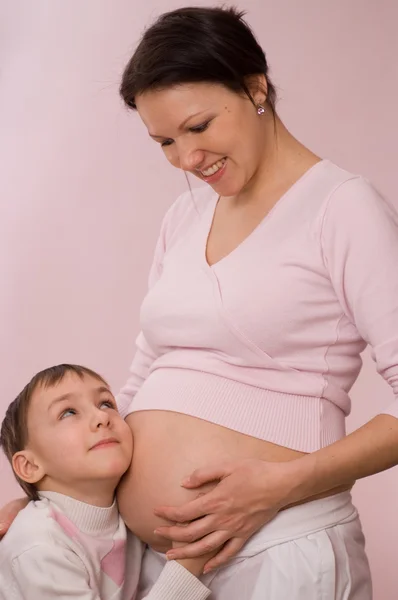 Bastante embarazada madre abrazando a su hijo —  Fotos de Stock
