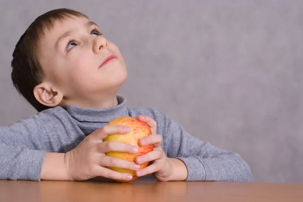 Ребенок сидит рядом с яблоком — стоковое фото