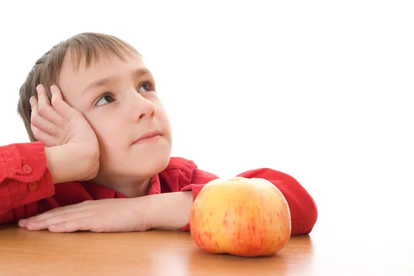 Junge sitzt neben einem Apfel und träumt — Stockfoto