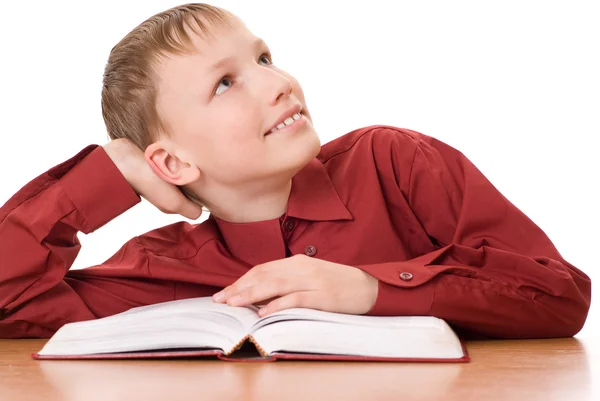 Junge sitzt mit einem Buch und träumt — Stockfoto