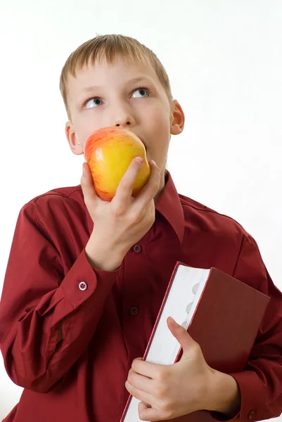 Junge im roten Hemd isst einen Apfel — Stockfoto