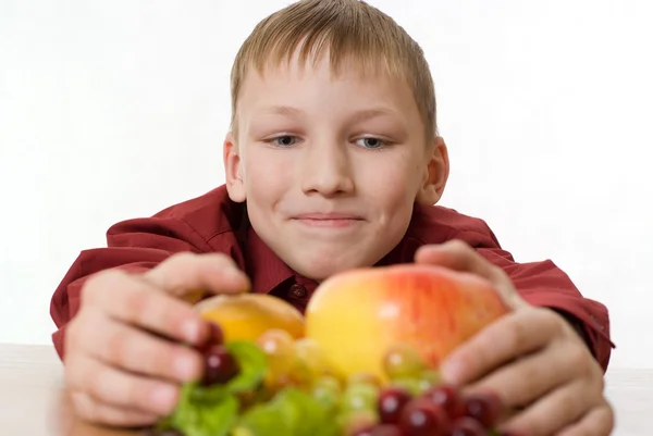 Rapaz puxa-se para a fruta — Fotografia de Stock