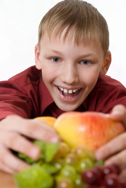 Sorrindo menino puxa-se para a fruta — Fotografia de Stock