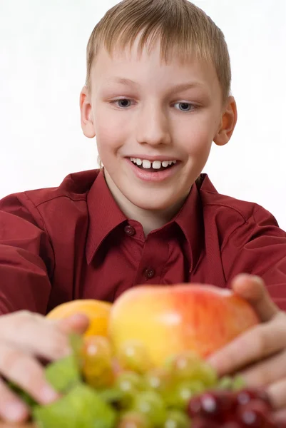 Junge zieht es zu viel Obst — Stockfoto