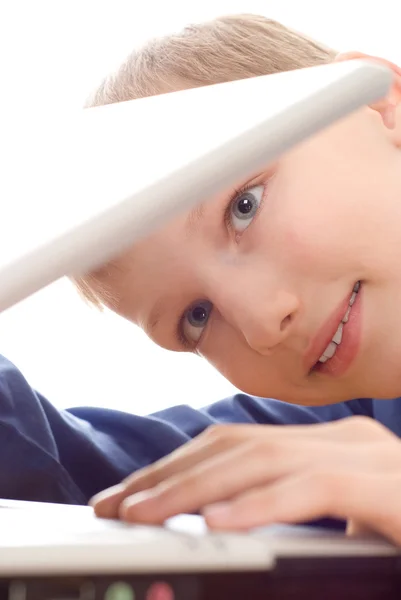 Мальчик улыбается и смотрит в ноутбук — стоковое фото