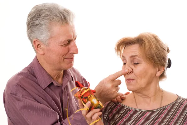 Happy elderly couple with a gift — Stock Photo, Image