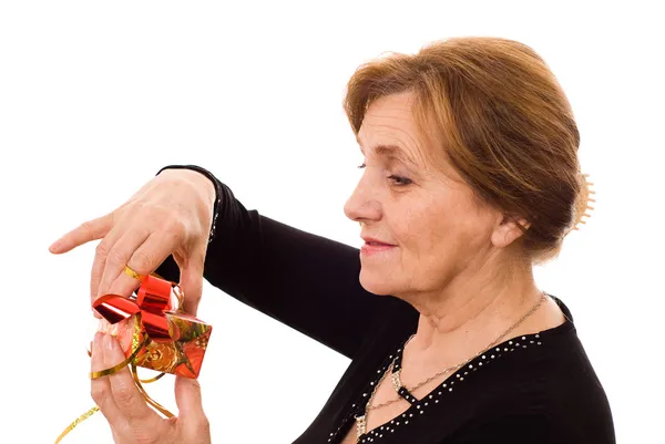 stock image Older woman opens a gift