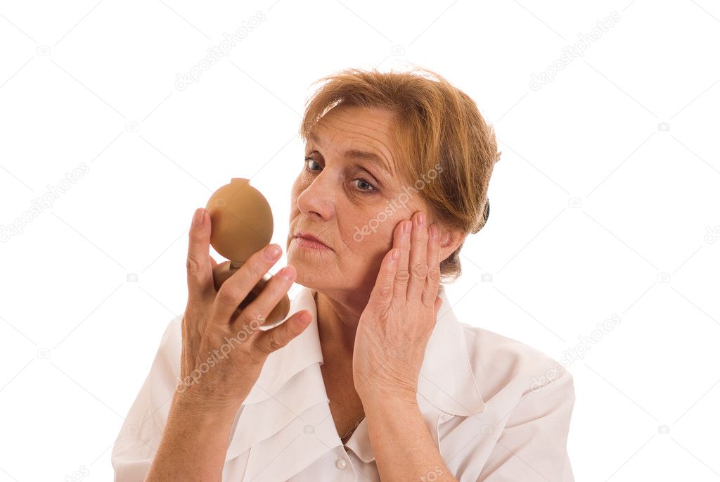 Elderly woman looks in the mirror