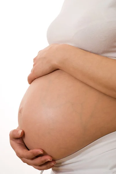 Mujer embarazada cogida de la mano en el estómago — Foto de Stock