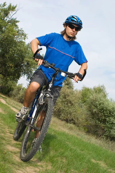 年轻自行车上戴着蓝色头盔 — 图库照片