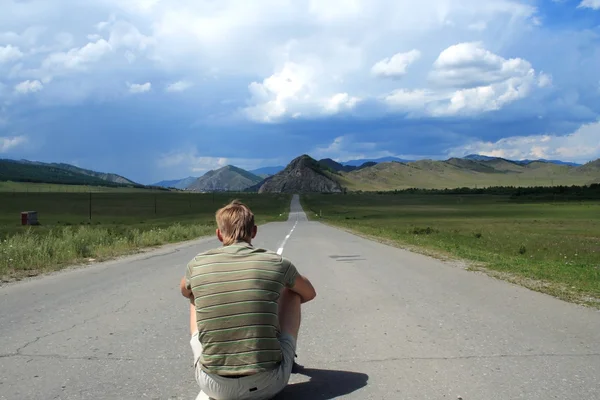 Человек сидит на дороге — стоковое фото