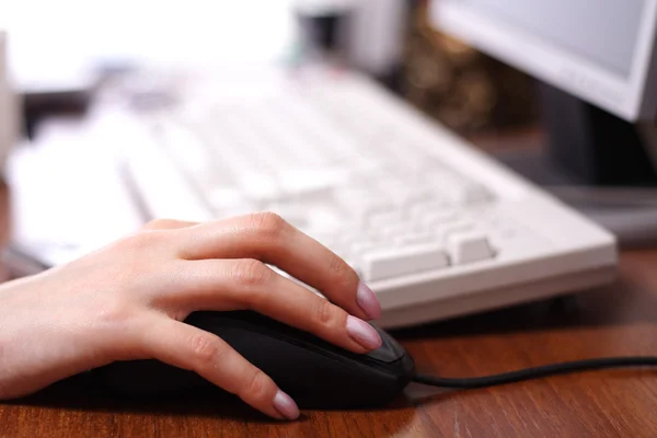 Женщина кладет руку на компьютерную мышь Лицензионные Стоковые Фото