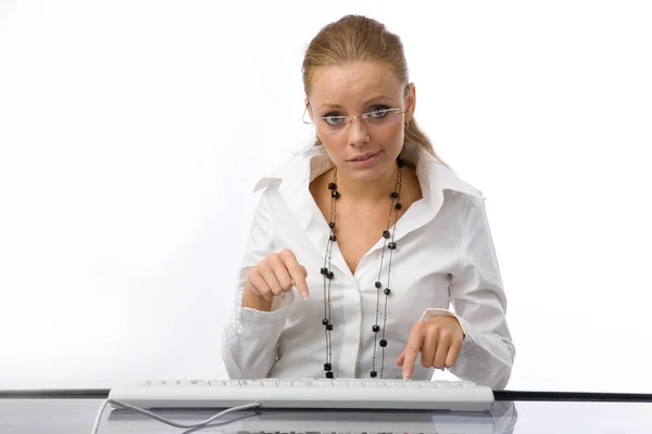 The girl puzzled prints on the keyboard — Stock Photo, Image