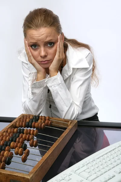 A sad girl with keyboard and bills — Stock Photo, Image