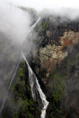 Fog and waterfall in Norway clipart