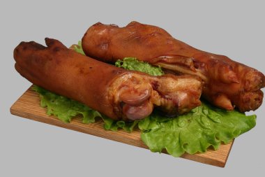 Smoked trotters on wooden board. clipart