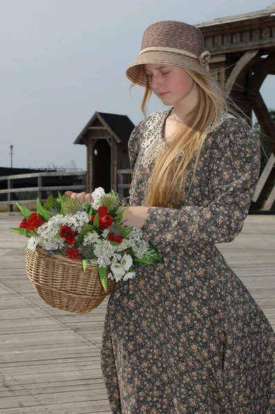 Flicka med korg med blommor — Stockfoto