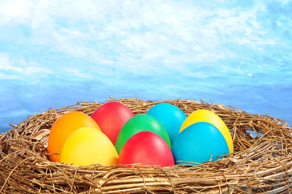 Αυγά χρώματος σε μια χρυσή φωλιά — Φωτογραφία Αρχείου