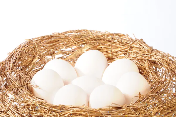Белые яйца в золотом гнезде Стоковая Картинка