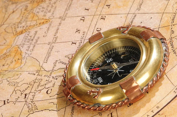 Ouderwetse kompas op een eeuwenoude kaart — Stockfoto