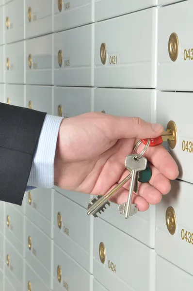 Hand with keys opening a deposit cell — Stock Photo, Image