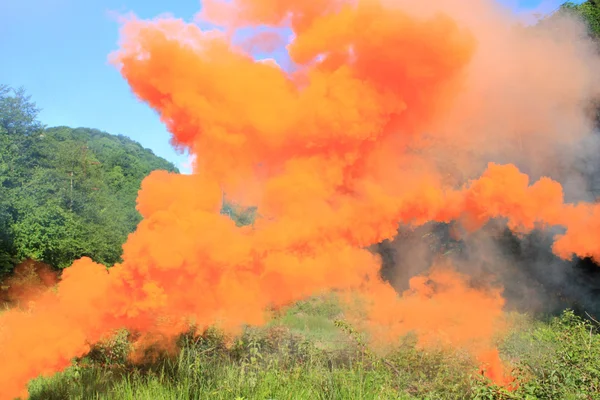 Fumo arancione sopra una radura di montagna — Foto Stock