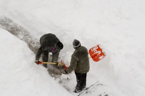 2 arbetstagare rengöring djup snö. Stockbild