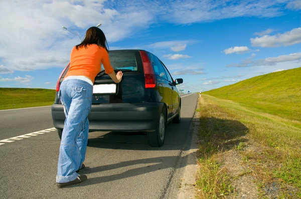 Kobieta pchanie samochodu — Zdjęcie stockowe