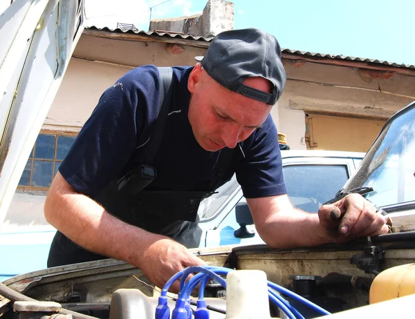 Uomo che ripara una vecchia auto — Foto Stock