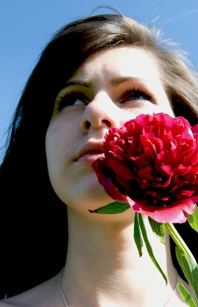Vacker kvinna med röd blomma — Stockfoto