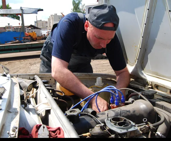 Человек ремонтирует старую машину — стоковое фото