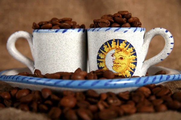Copos, pratos e grãos de café — Fotografia de Stock