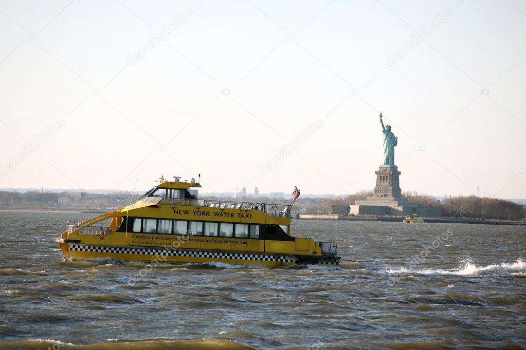 NY water taxi on background Statue of Li