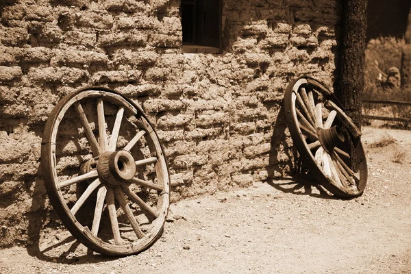 Старе колесо з вінтажного візка біля стіни — стокове фото