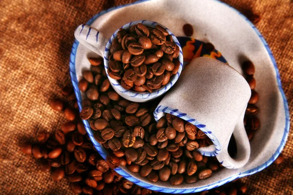 Чашка, блюдо и бобы кофе — стоковое фото