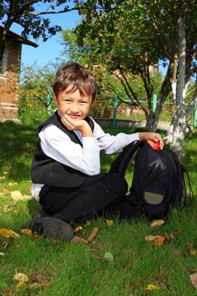 Skolpojke med ryggsäck och äpple — Stockfoto