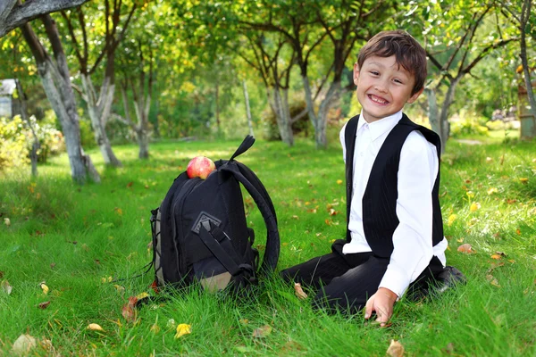 Школярка з рюкзаком і яблуком — стокове фото