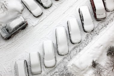 Great snowfall covered cars in city clipart