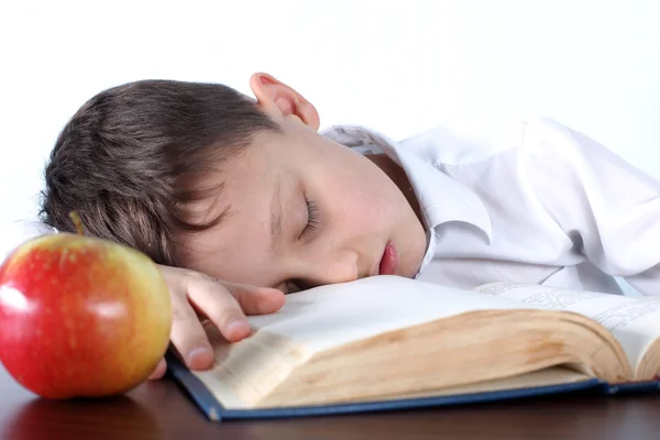 Menino dormindo no livro na maçã — Fotografia de Stock