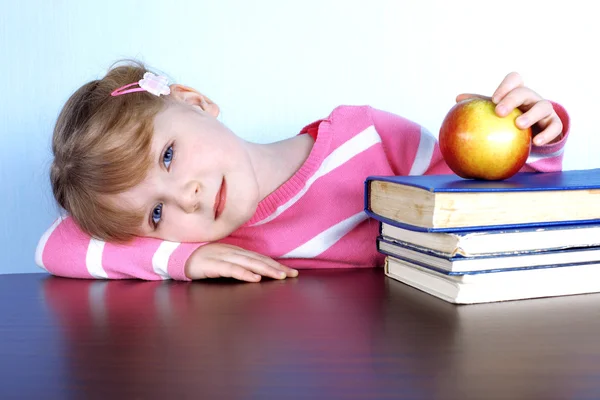Dziewczynka z jabłkiem i książek — Zdjęcie stockowe