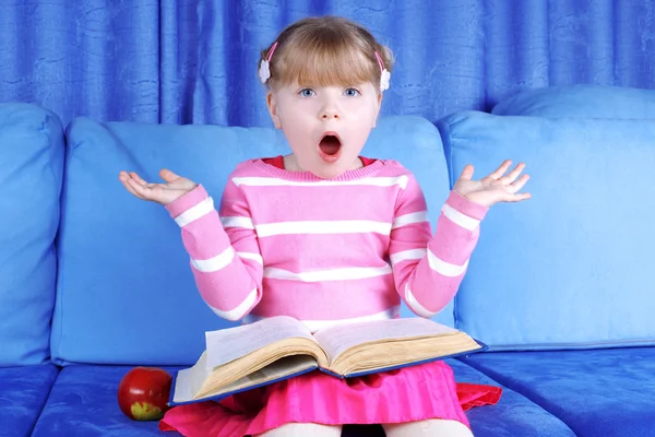 Удивлённая девушка с яблоком и книгами — стоковое фото