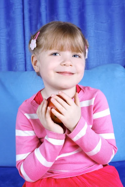 Šťastná dívka s apple v pohovce — Stock fotografie