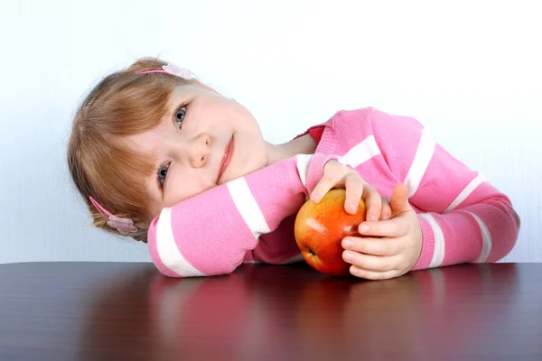 Мечтающая маленькая девочка с яблоком — стоковое фото
