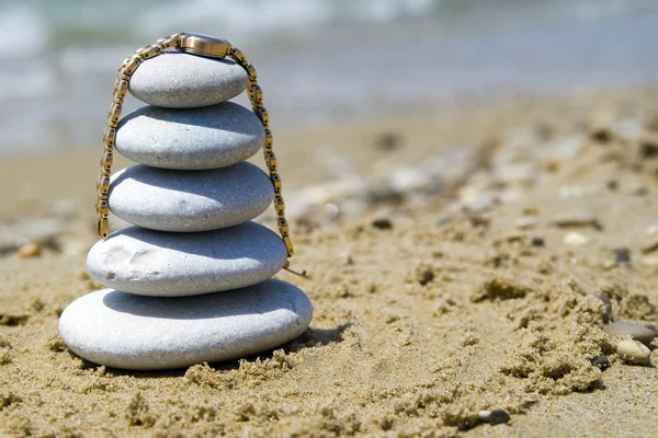 Pebble stack with watch on the seashore — Stock Photo, Image