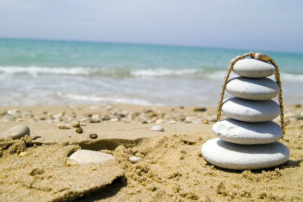 Pila di ciottoli con orologio in riva al mare — Foto Stock