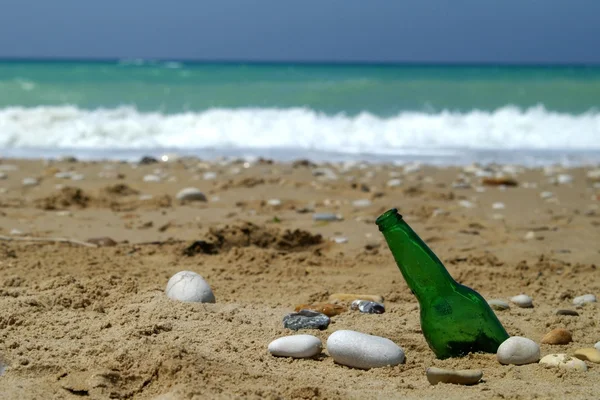 Botella sobre arena cerca del agua —  Fotos de Stock