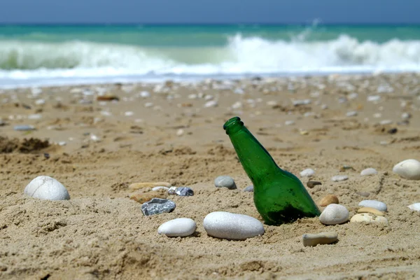 Láhev na písku u vody — Stock fotografie