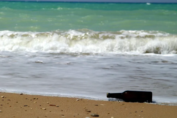 Láhev na písku u vody — Stock fotografie